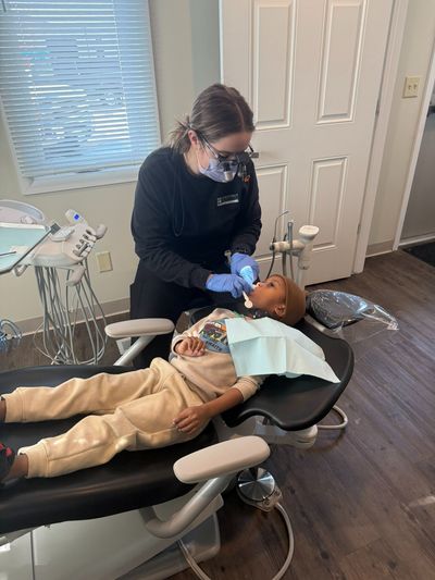 Dr. Annie giving a young patient a dental exam