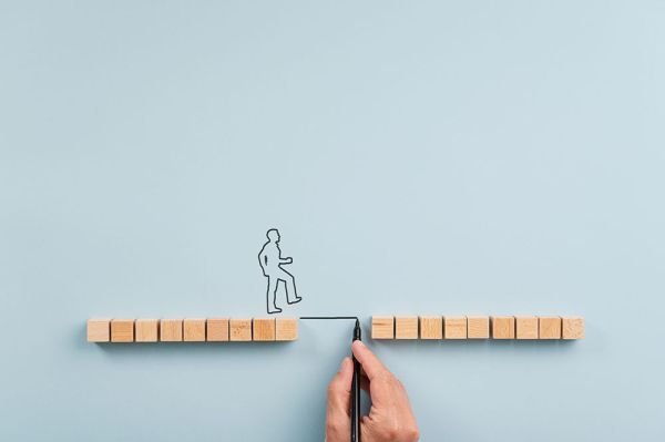 a figure getting help crossing a gap